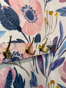 wallpaper covering a coat hook board so it blends into the wallpaper