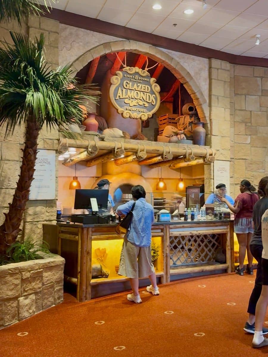 Woman buying glazed almonds at a counter.