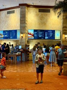 People standing in front of a concession stand in a theater lobby.