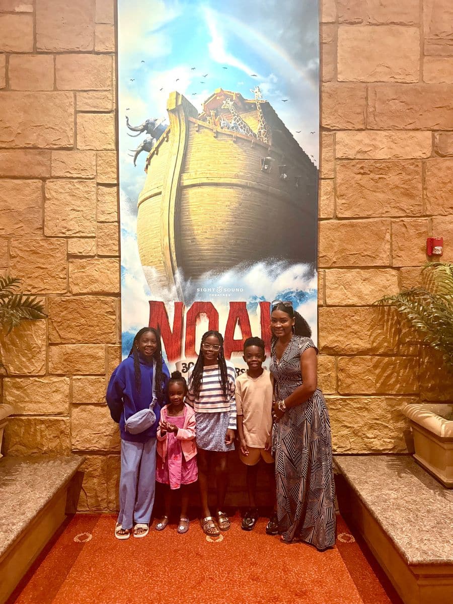 Family standing in front of Noah's Arc banner.