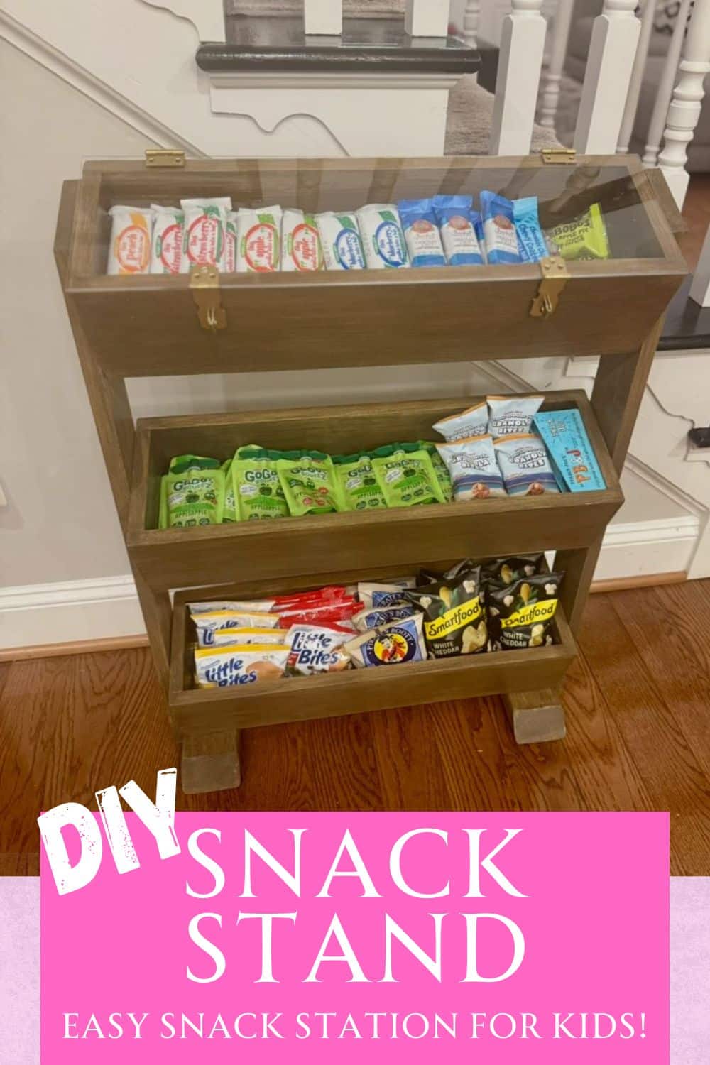 Wooden snack stand or snack organizer station filled with kids snacks and covered with a piece of plexiglass that can be locked.